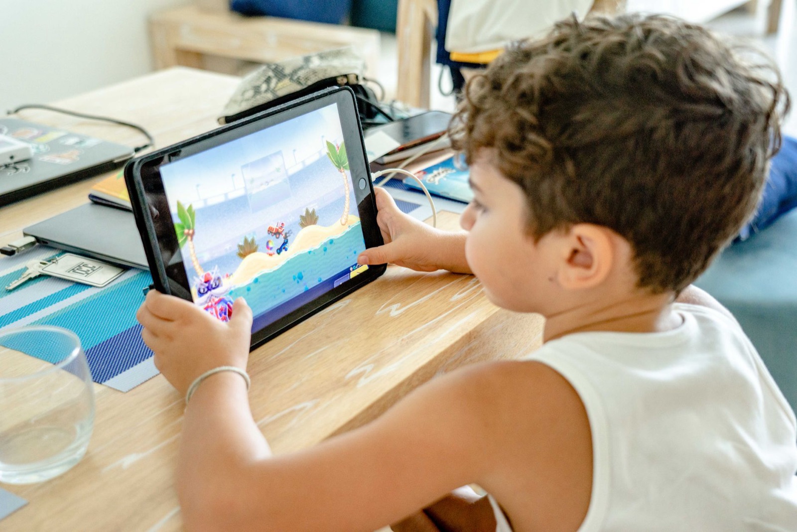 Ein kleiner Junge ist zu Hause ganz in ein Videospiel auf einem Tablet vertieft.