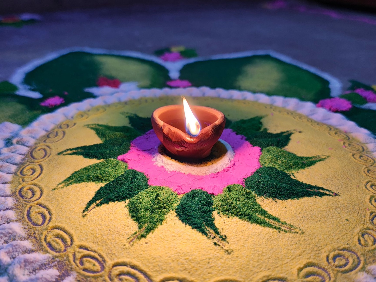 Colorful Rangoli design with a lit diya, symbolizing Diwali celebrations and cultural traditions.