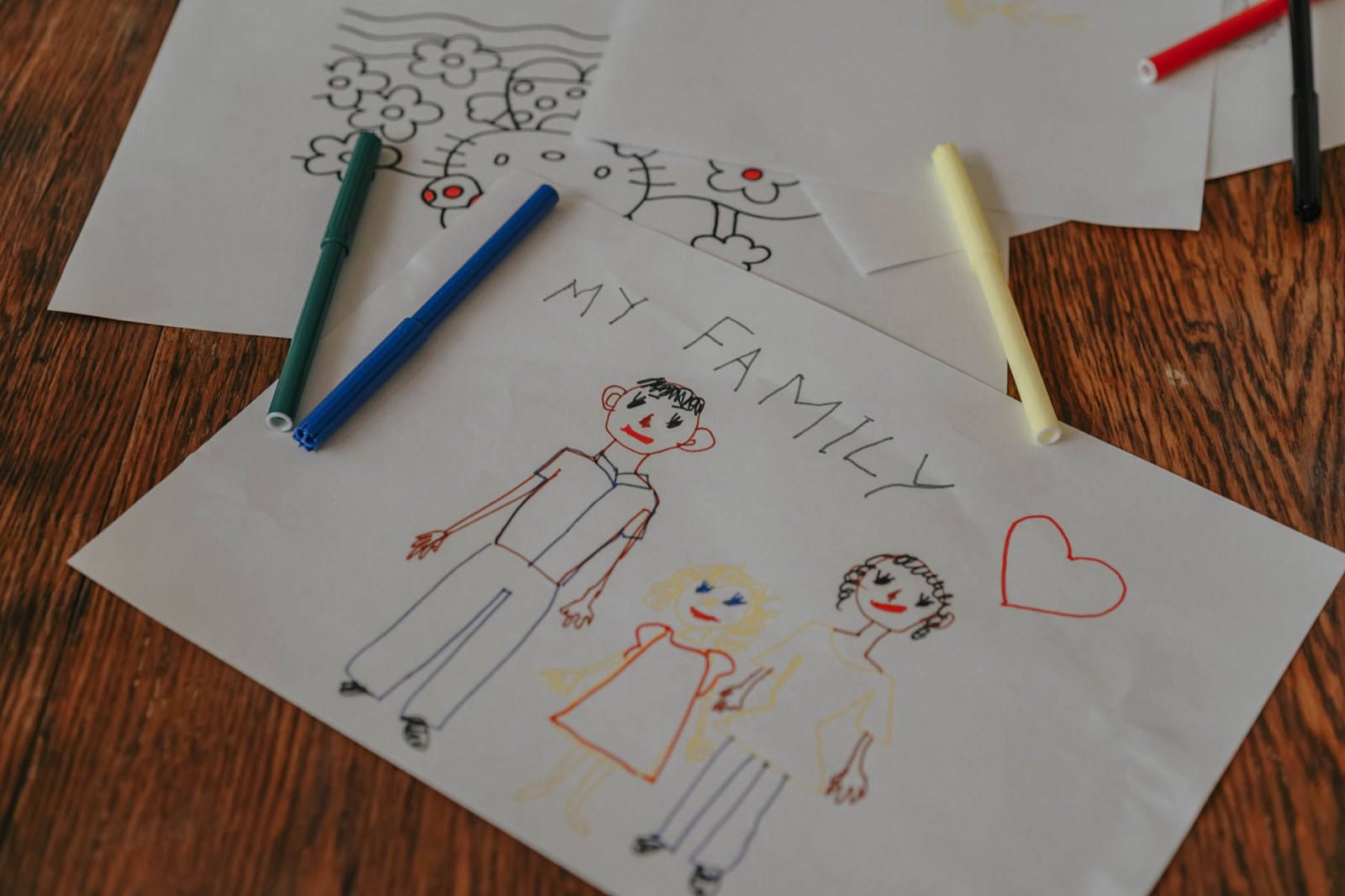 A hand-drawn family portrait using colored markers on paper, showcasing creativity and love.