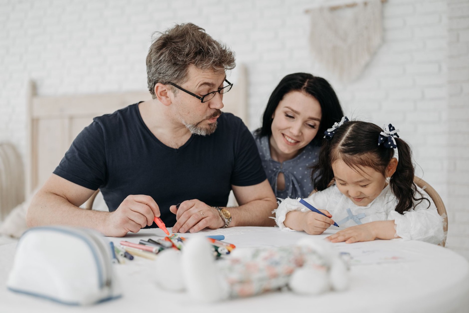 A joyful family spends quality time together drawing at home, fostering creativity and bonding.