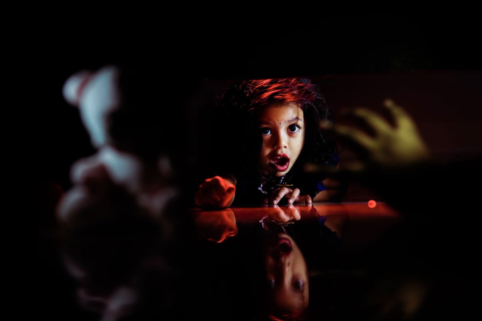 A child looks surprised while hiding, creating a dramatic moment of curiosity and play.