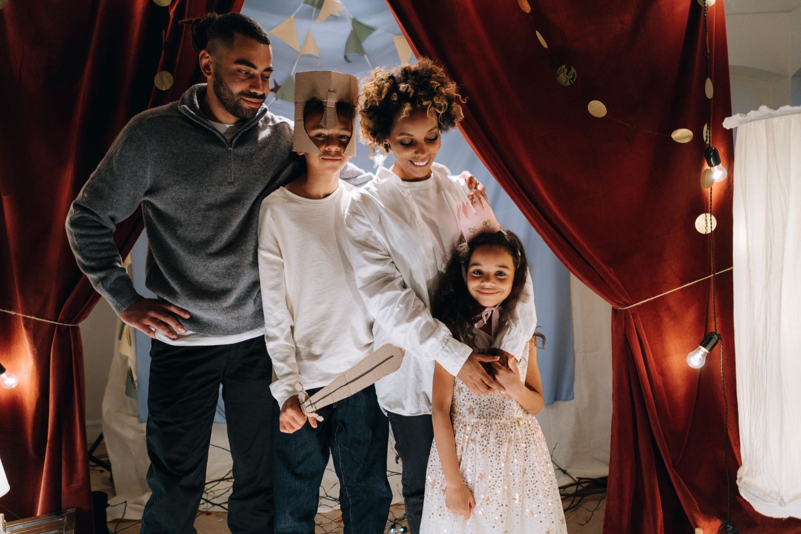 A family enjoying a playful theater night at home with kids dressed as actors. Warm and joyful atmosphere.
