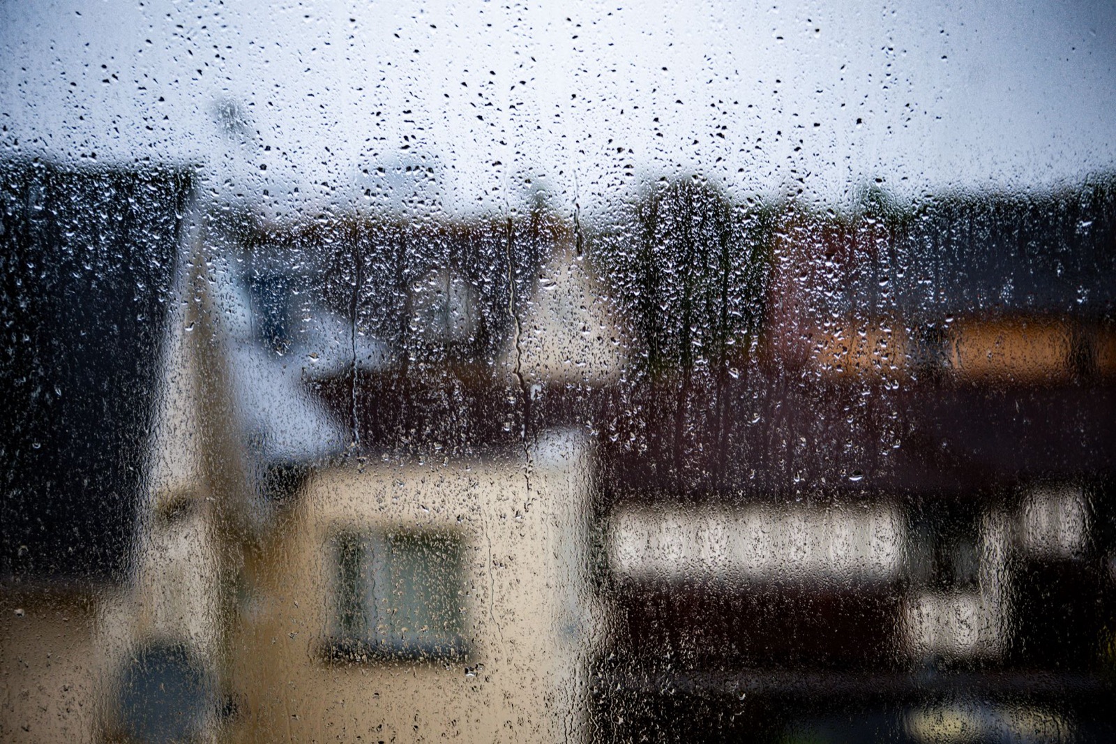 Blurred view of a rainy day in Bournemouth, capturing raindrops on a window.