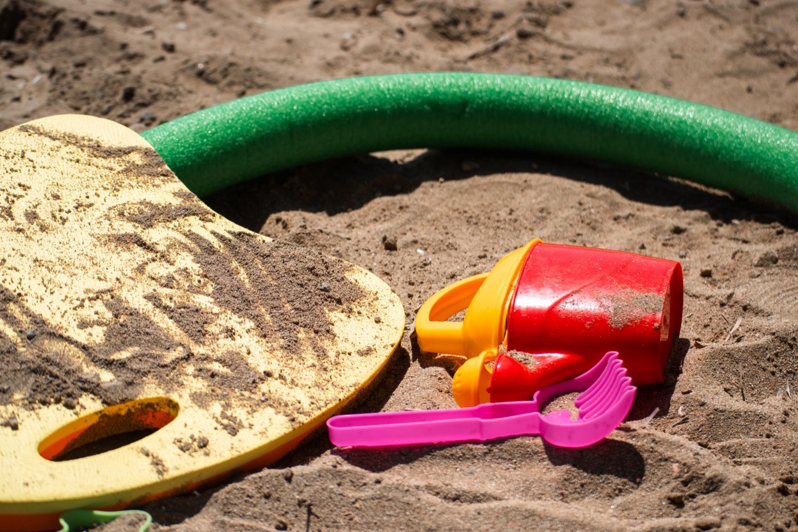 Vibrant sandbox toys in the sand, perfect for summer playtime fun.