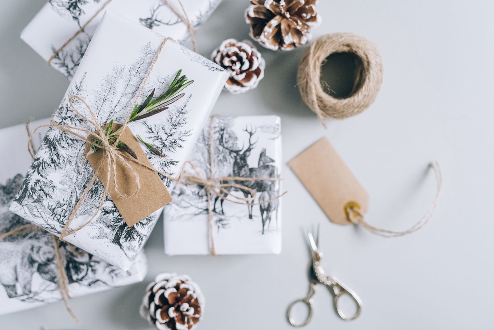 Styled Christmas gifts wrapped in nature-themed paper with pine cones and twine, perfect for holiday inspiration.
